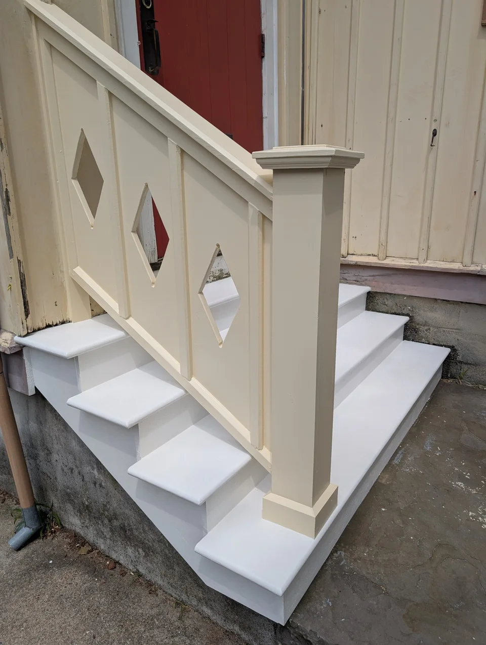 Cream entry railing with diamond details and a capped post.